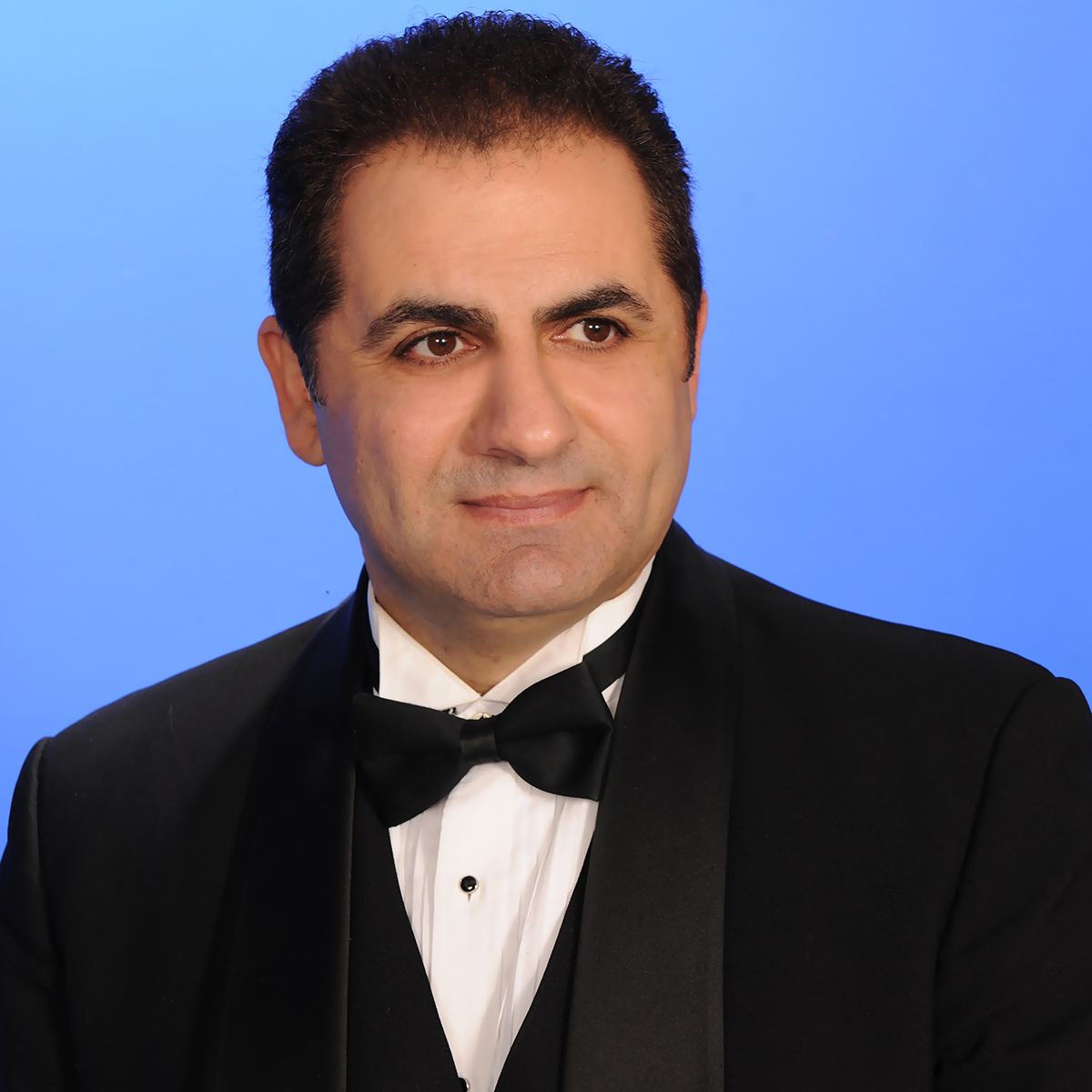 man wearing a tux against a blue background