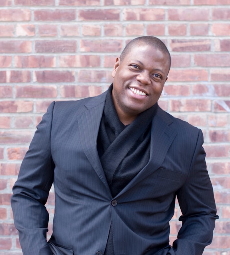 Alfred Walker standing in front of a brick wall