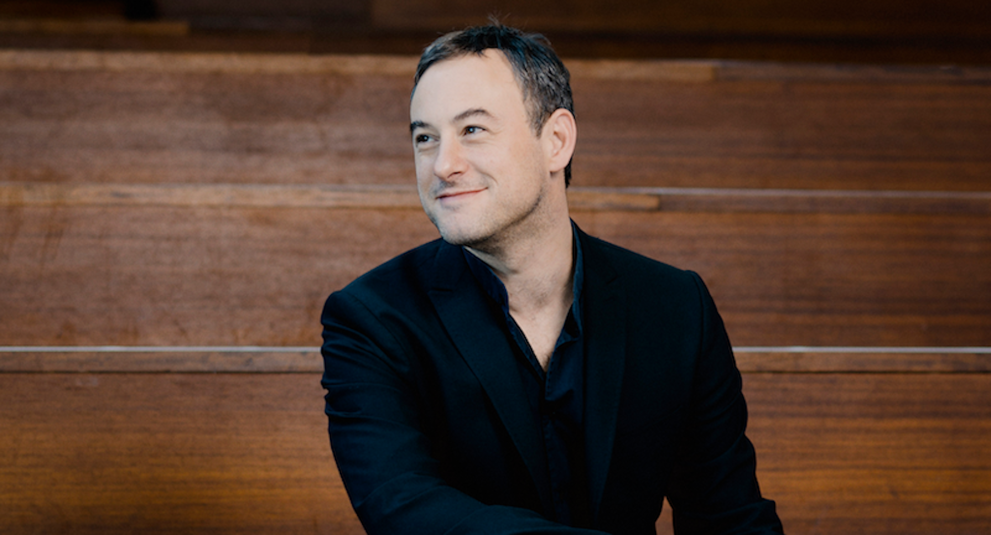 conductor Jonahan Cohen sitting and smiling