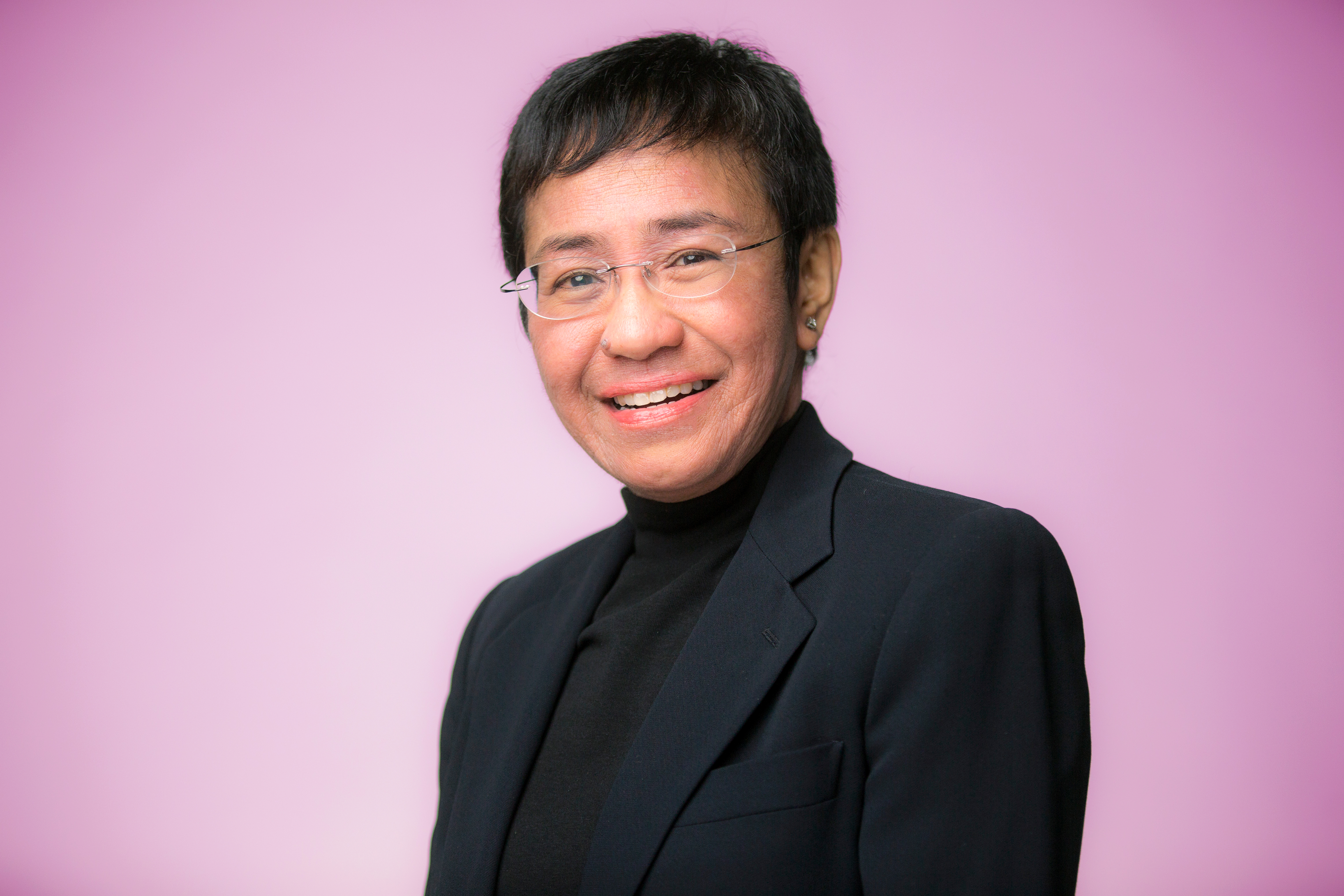 Maria Ressa in front of a pink background