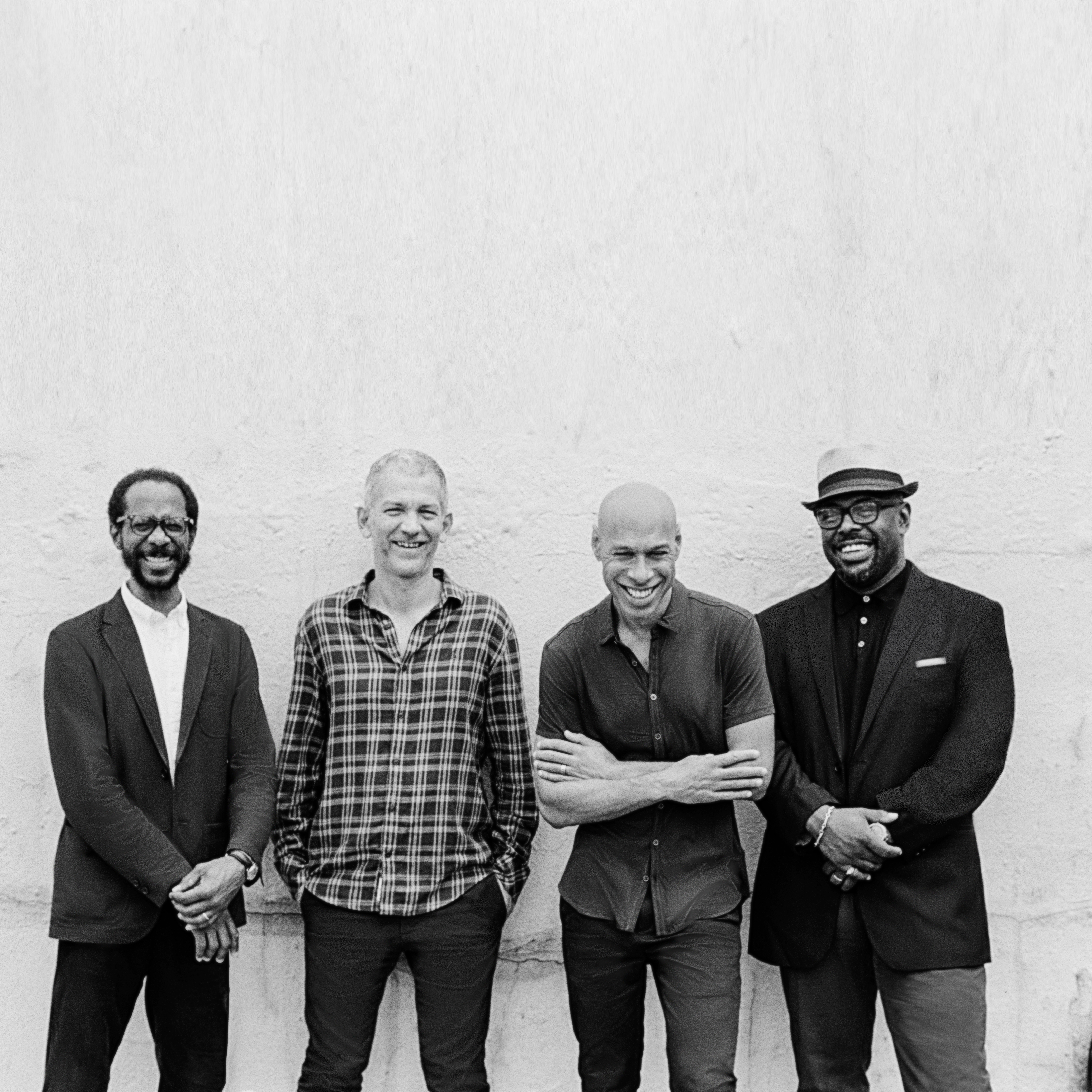 Joshua Redman, Brad Mehldau, Christian McBride, and Brian Blade standing together, smiling