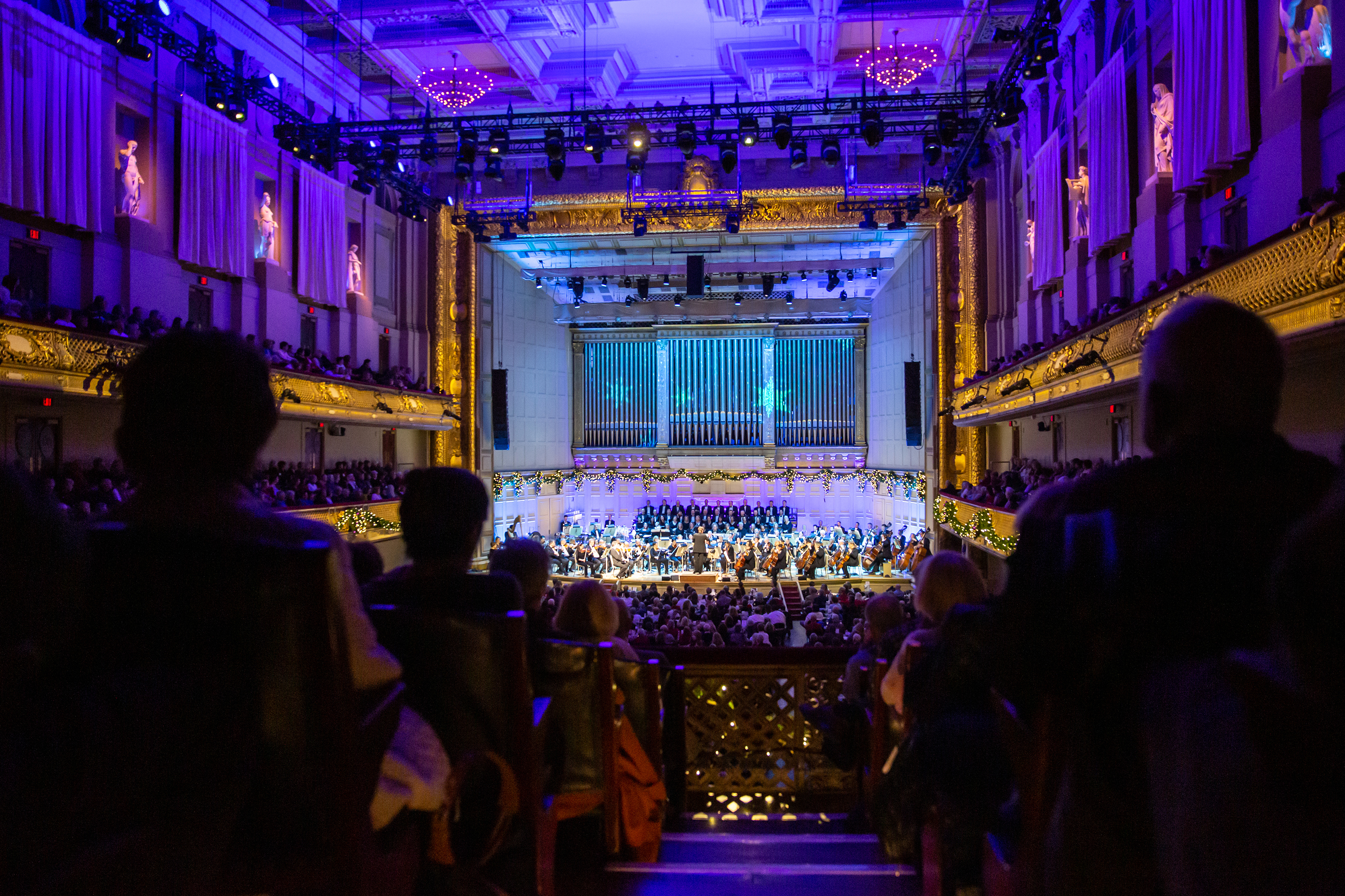 Audience members watch a Holiday Pops concert from the first balcony of Symphony Hall