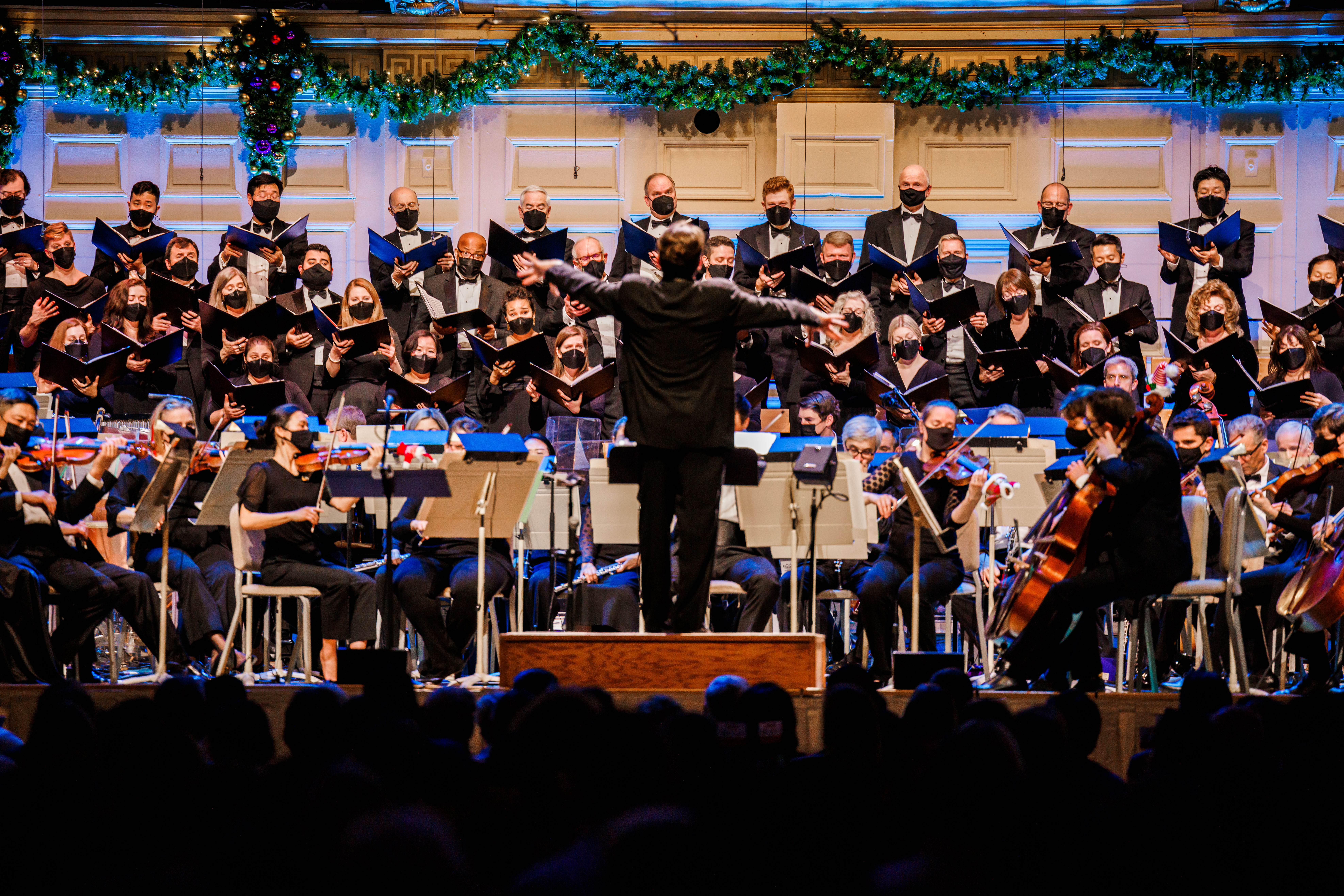 The Tanglewood Festival Chorus sings on stage in masks as Keith Lockhart conducts