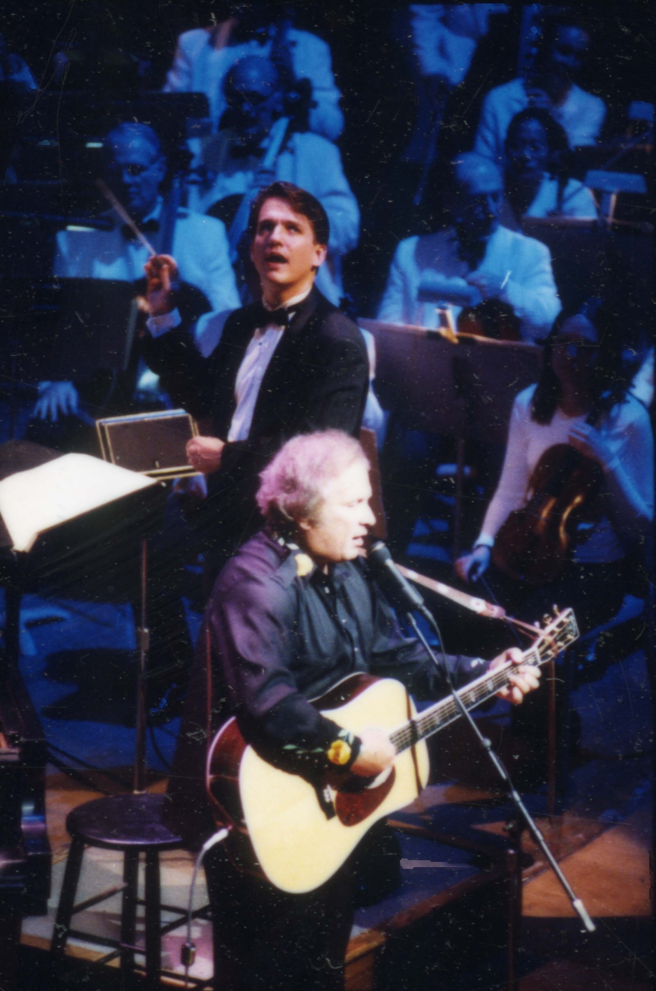 Don McLean sings and plays acoustic guitar on the Symphony Hall stage as Keith conducts the Pops behind him