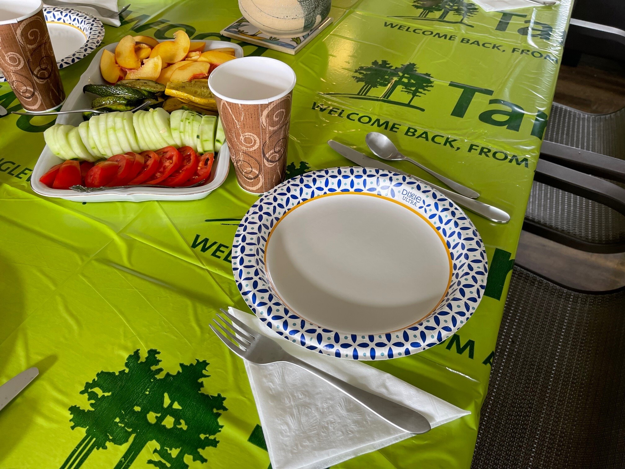 A plate and a tray of appetizers on top of a green branded tarp