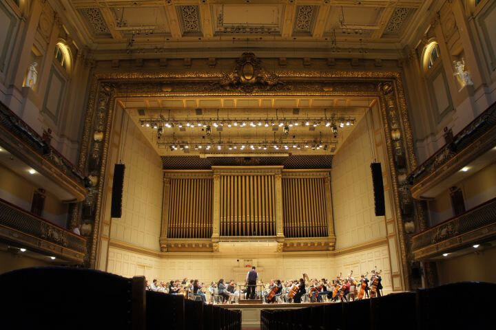 A ensemble performs on the stage of Boston Symphony Hall