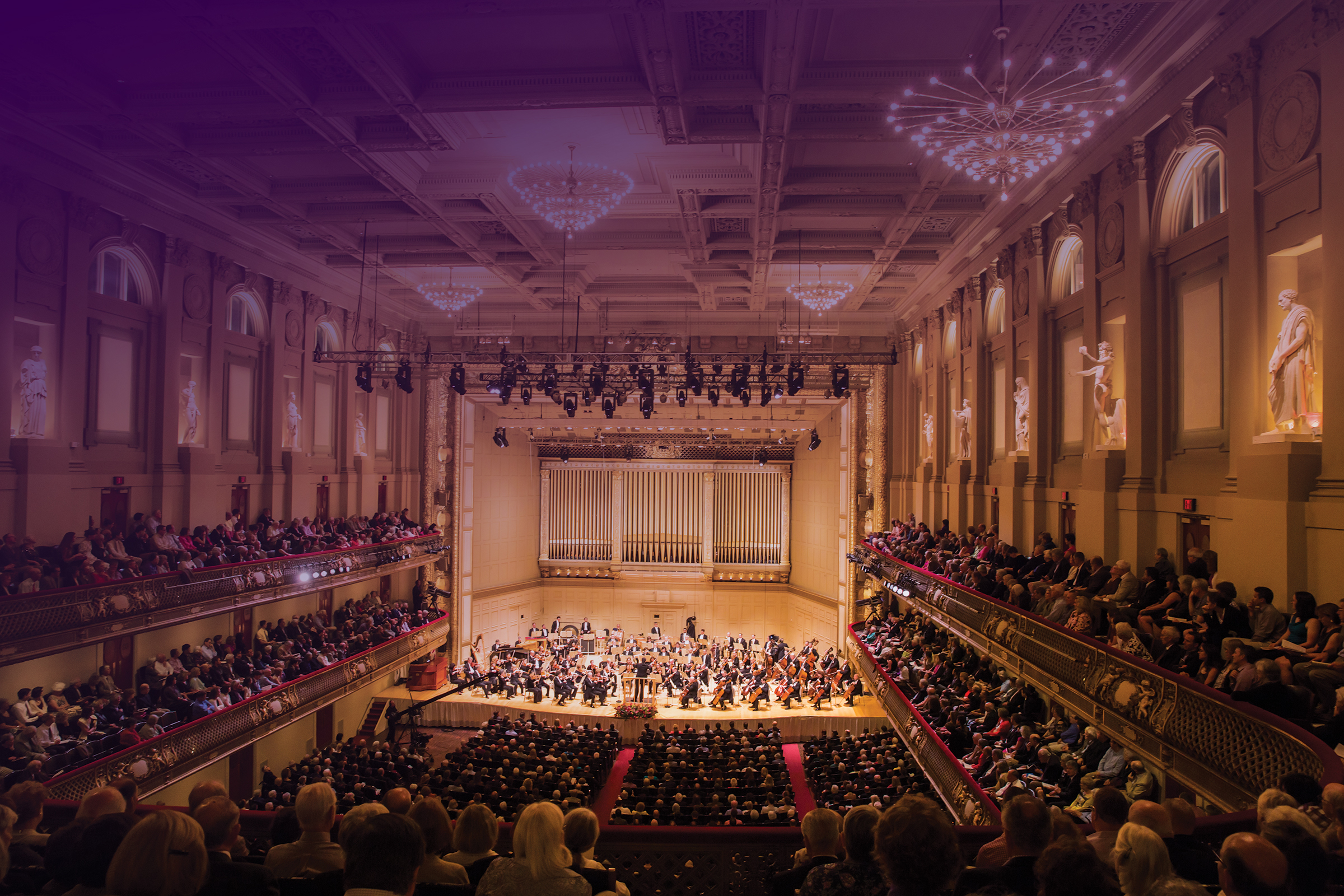 Full audience and orchestra in Boston Symphony Hall with a swirling purple overlay