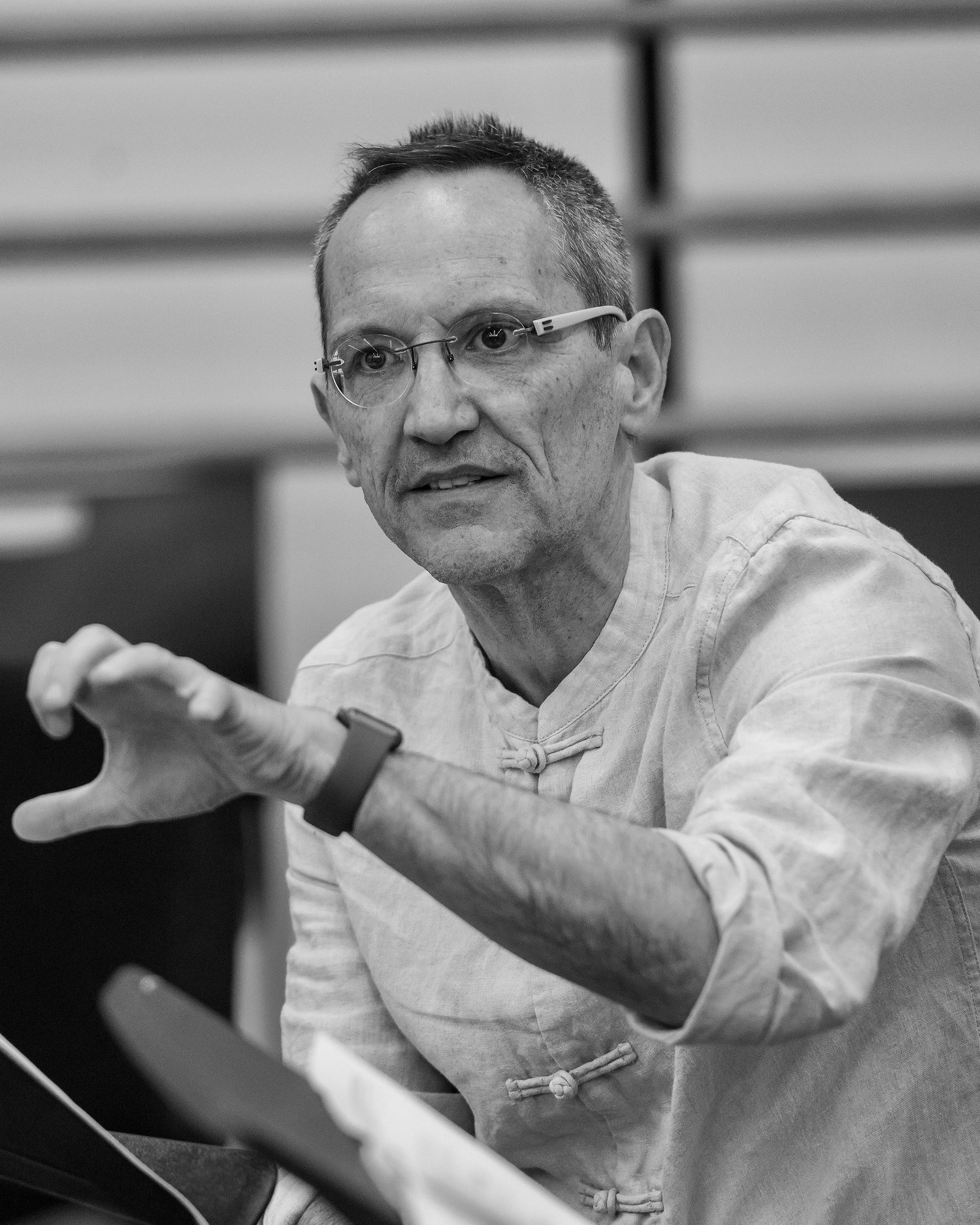 Black and white photo of Osvaldo Golijov sitting in front of a music stand.