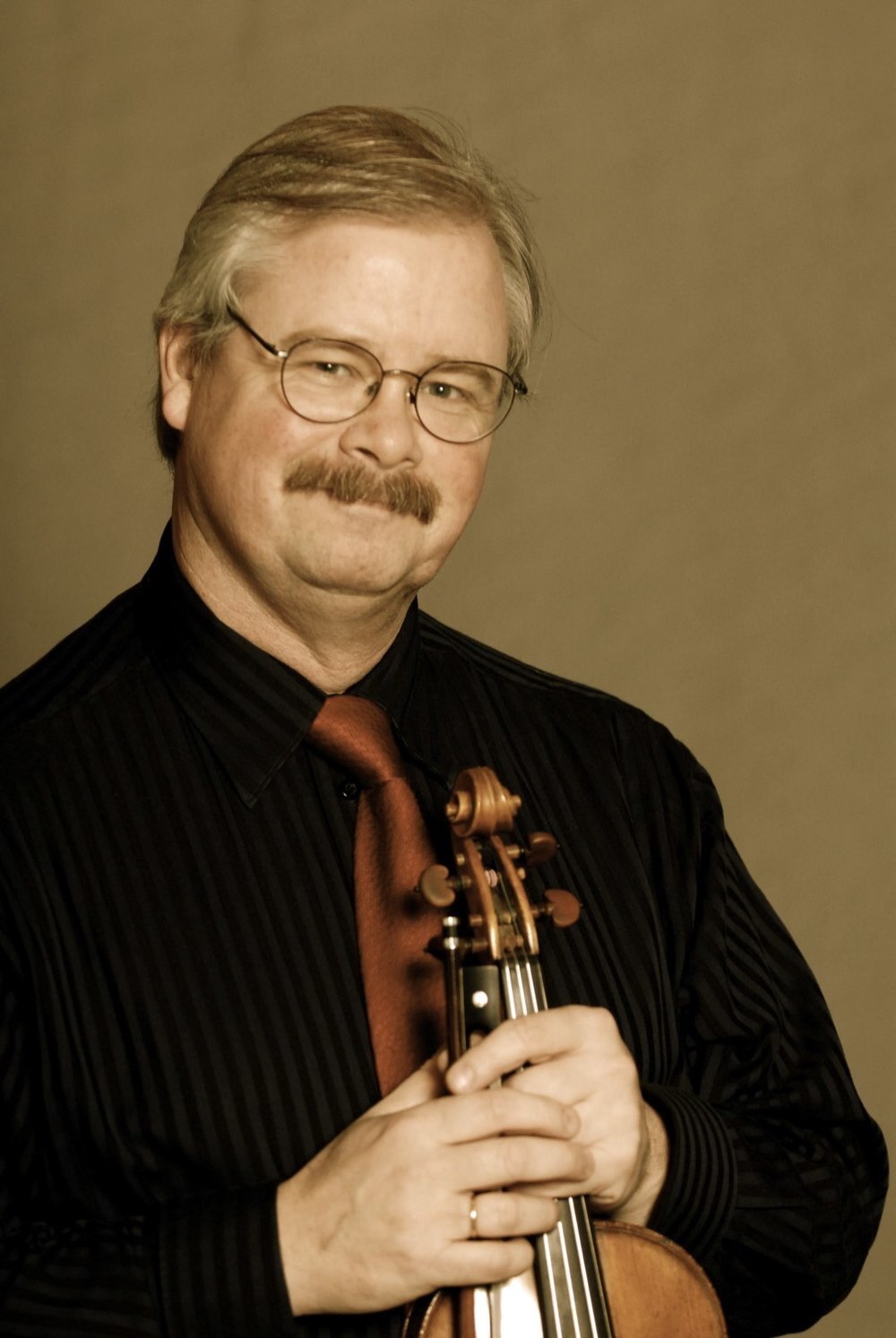 Andrew Jennings headshot holding his violin and bow