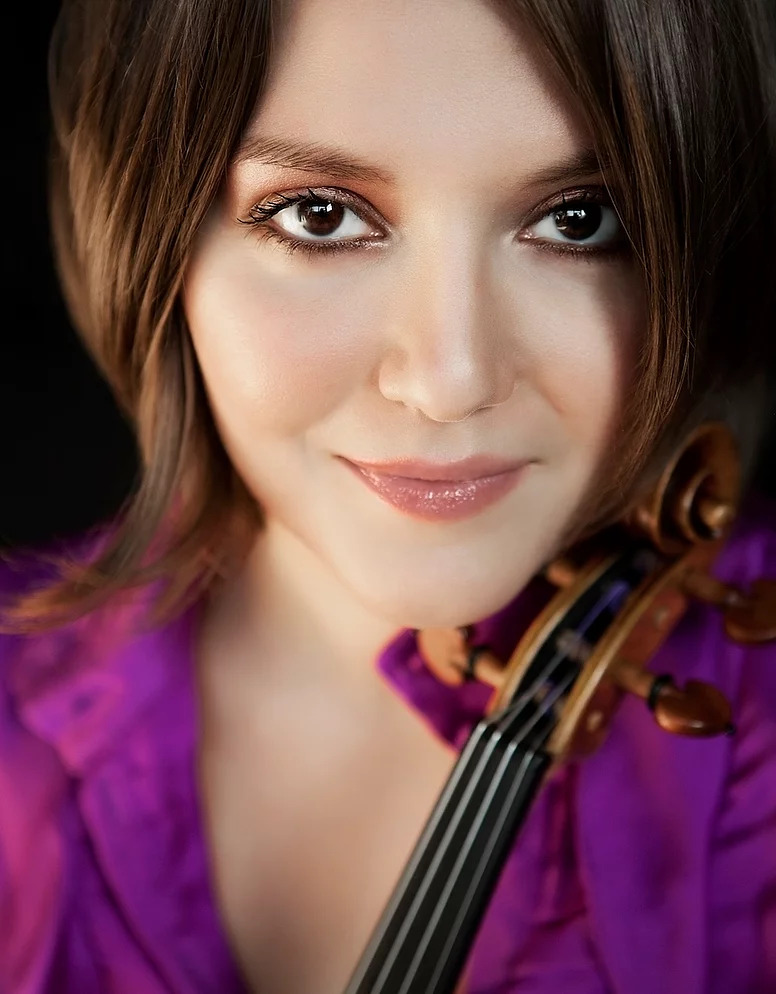 Areta Zhulla headshot with the scroll of her violin