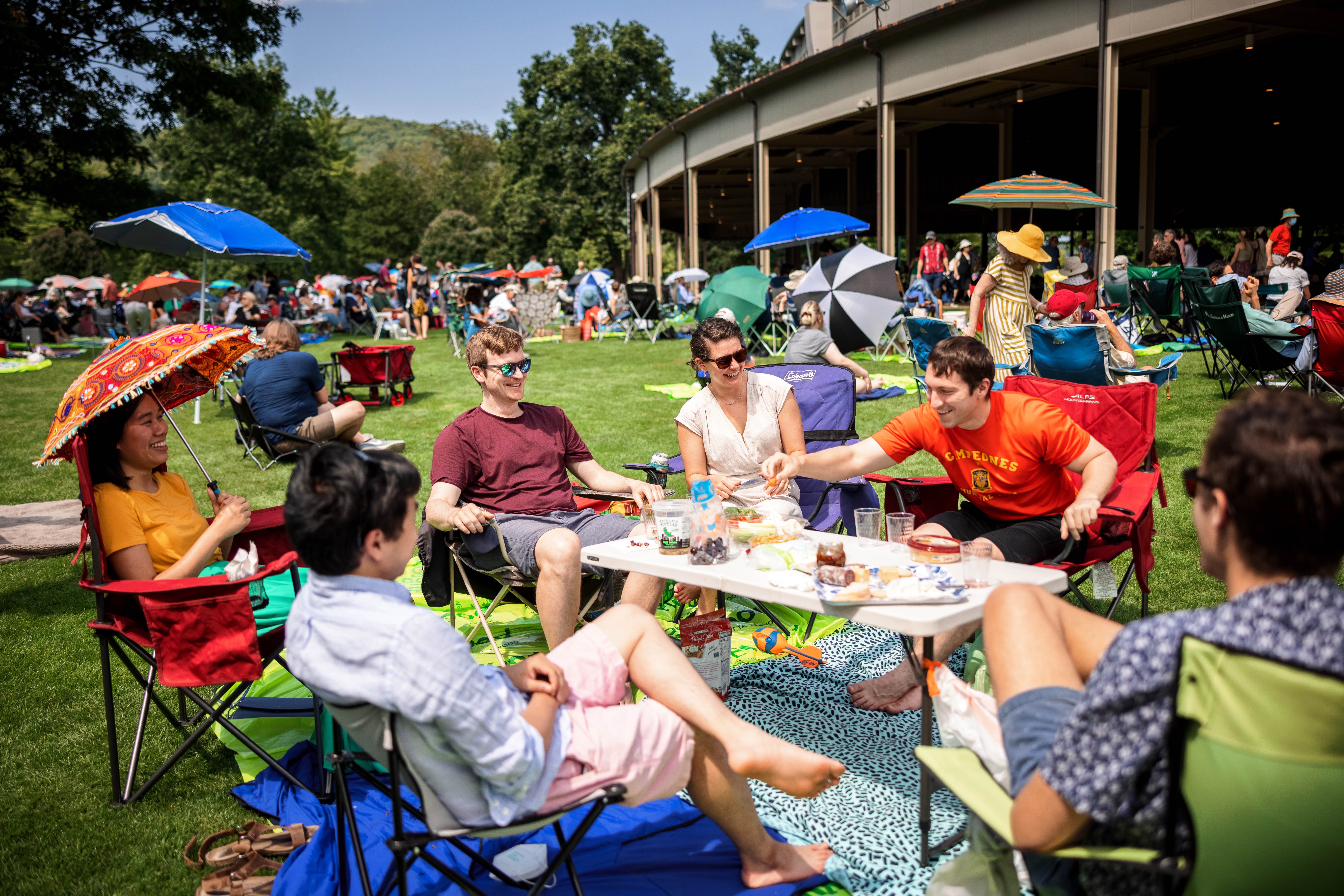People eating at a picnic table with the Koussevitzky Music Shed in the background