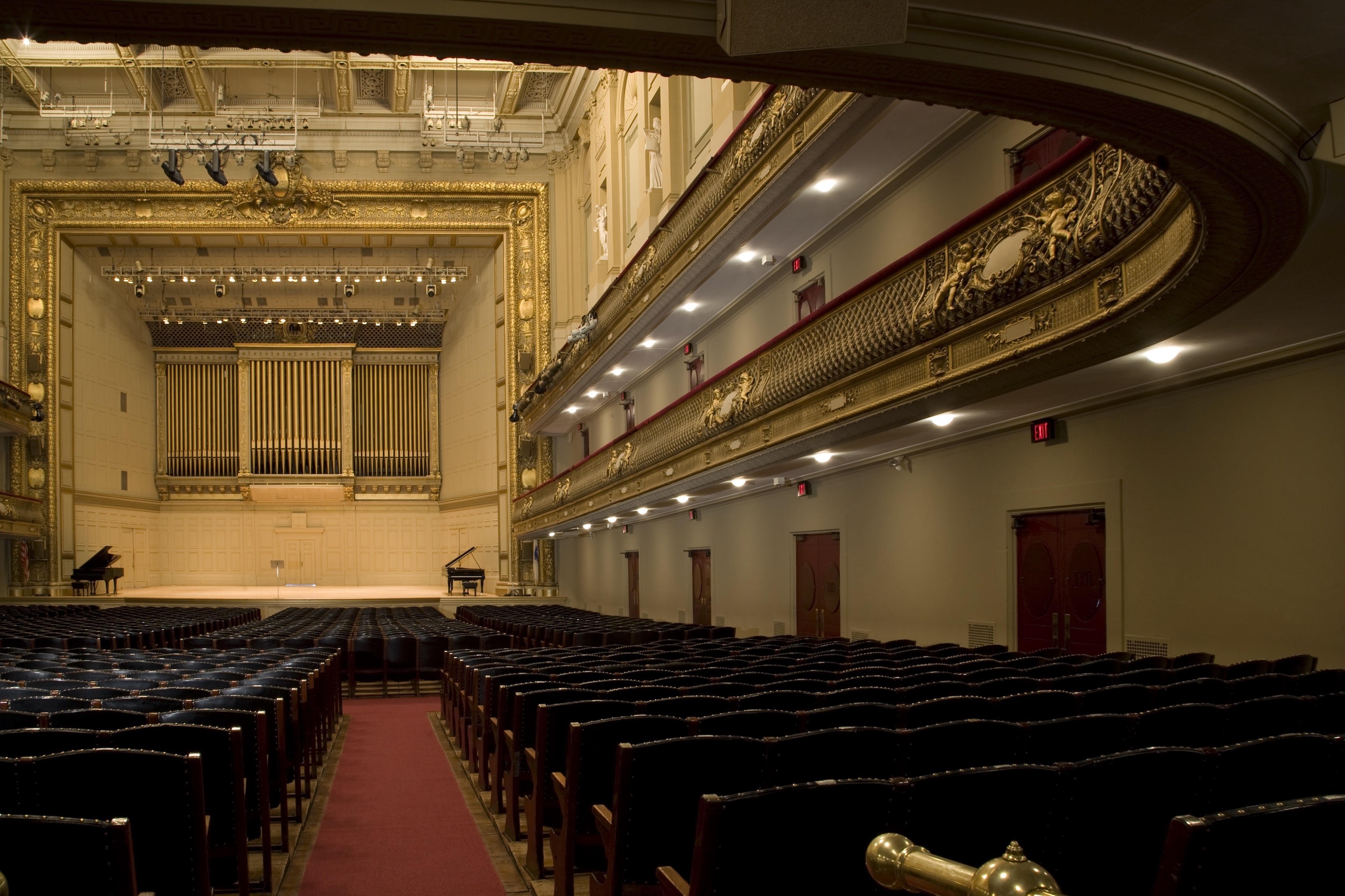 Photo of the Symphony Hall stage from the audience perspective with empty chairs