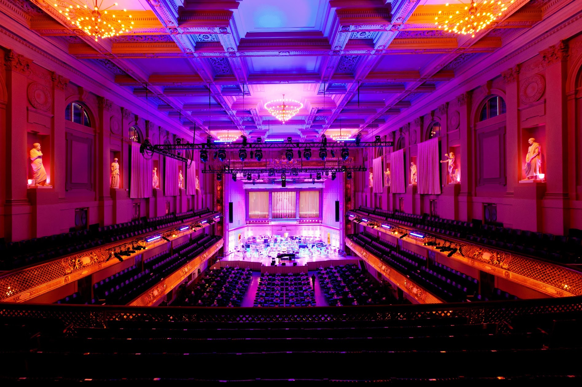 Wide shot of Symphony Hall auditorium, washed in purples and pinks, with no people inside.
