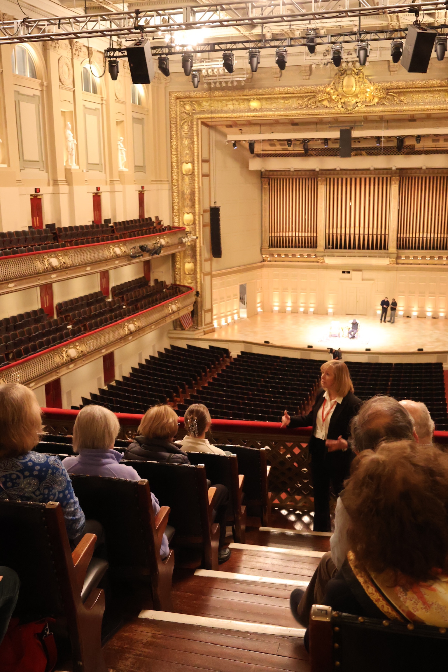 A guide speaking to a group on the second balcony inside Symphony Hall.